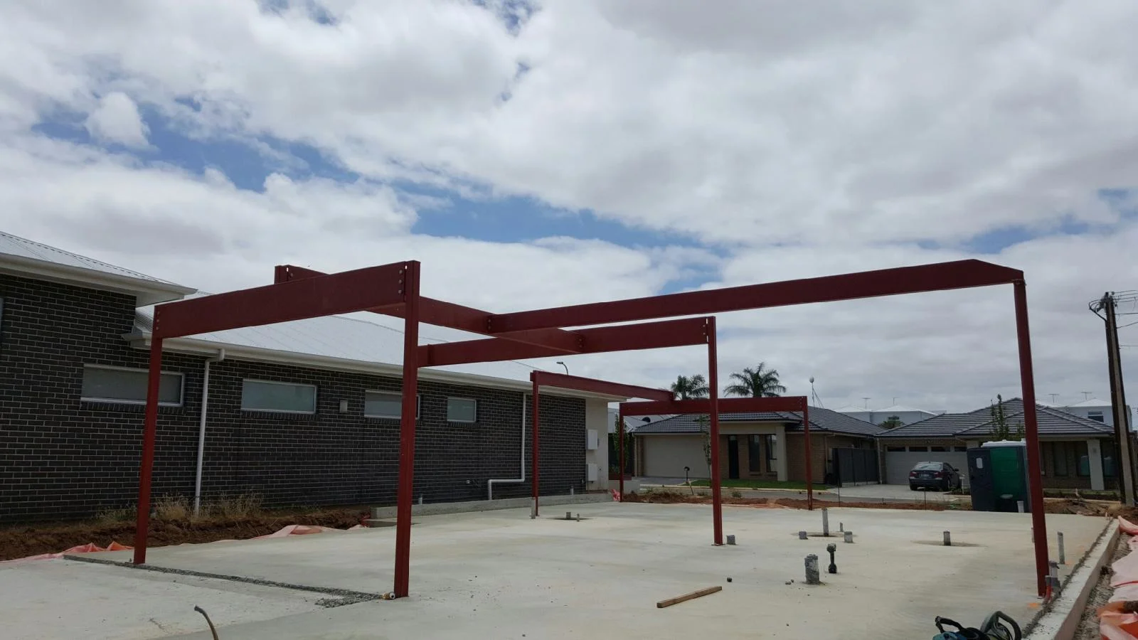 Red structural steel frame installed on a concrete slab