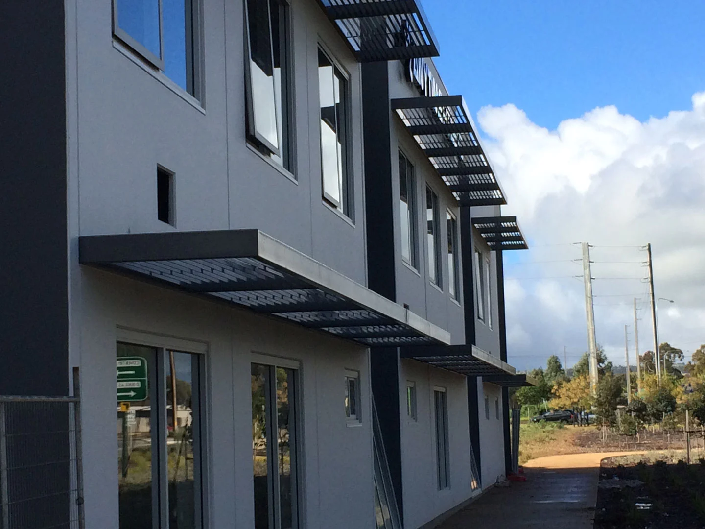 Cantilevered steel awning frame above building windows