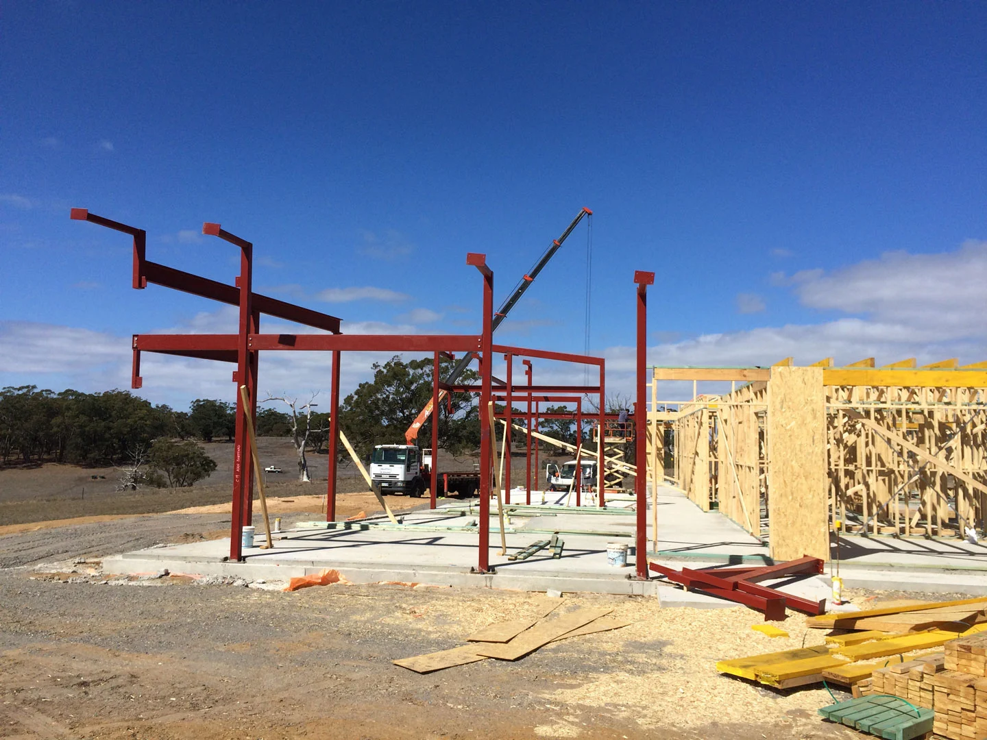 Red structural steel frame within a timber house build