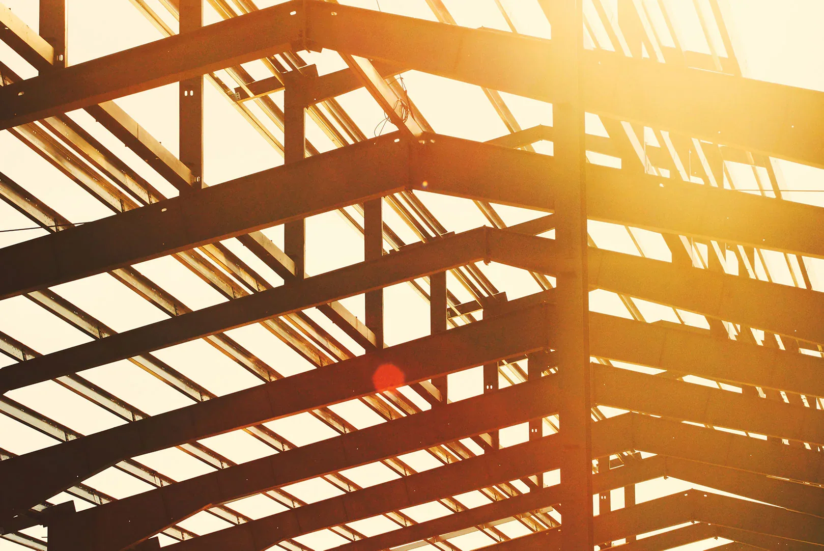 Structural steel roof frame lit by late afternoon sun